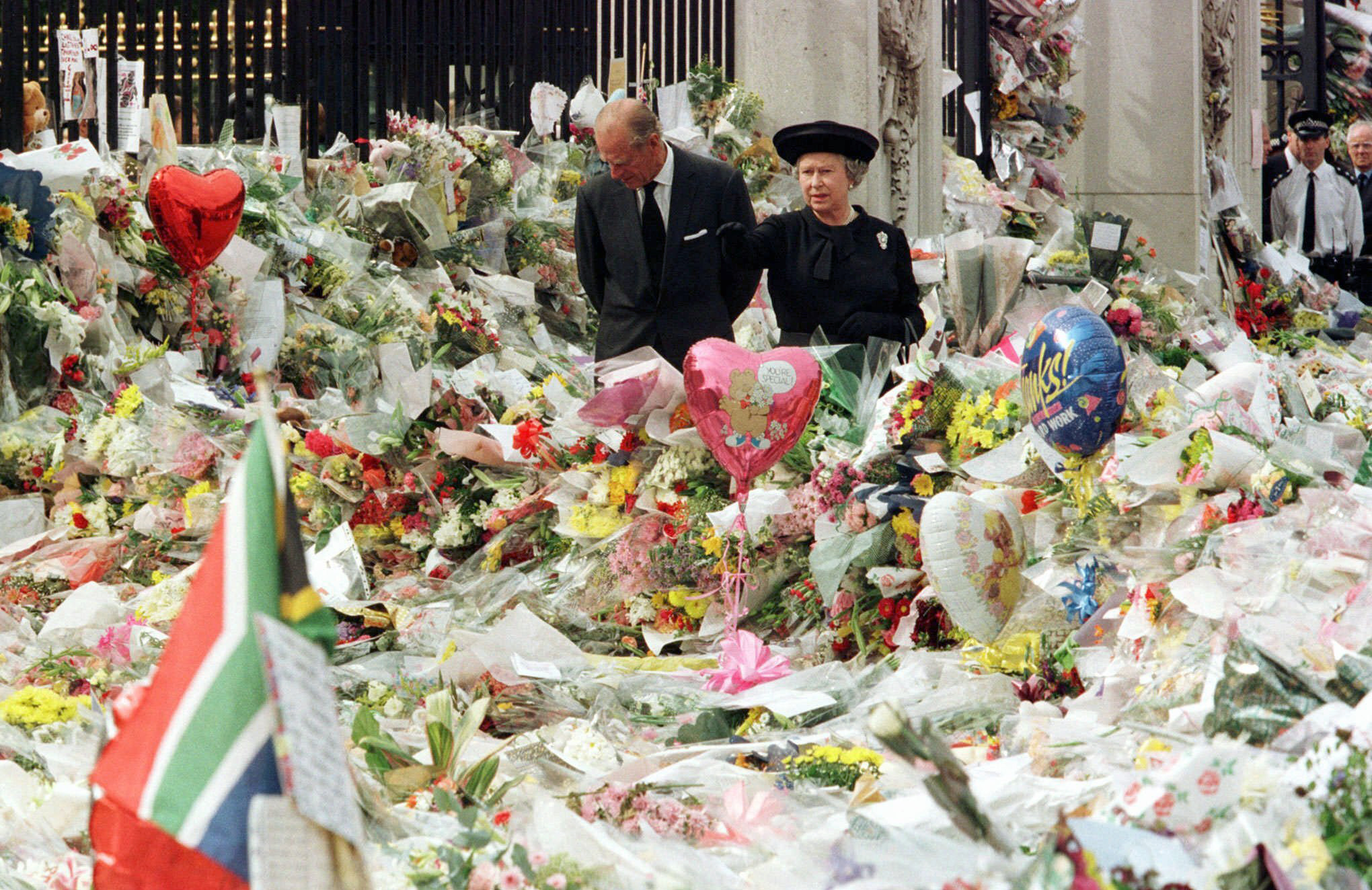 Britain's Queen Elizabeth II and Prince Philip view the floral tributes to Diana, Princess of Wales, at London's Buckingham Palace, Sept. 5, 1997. (Pool Photo via AP)