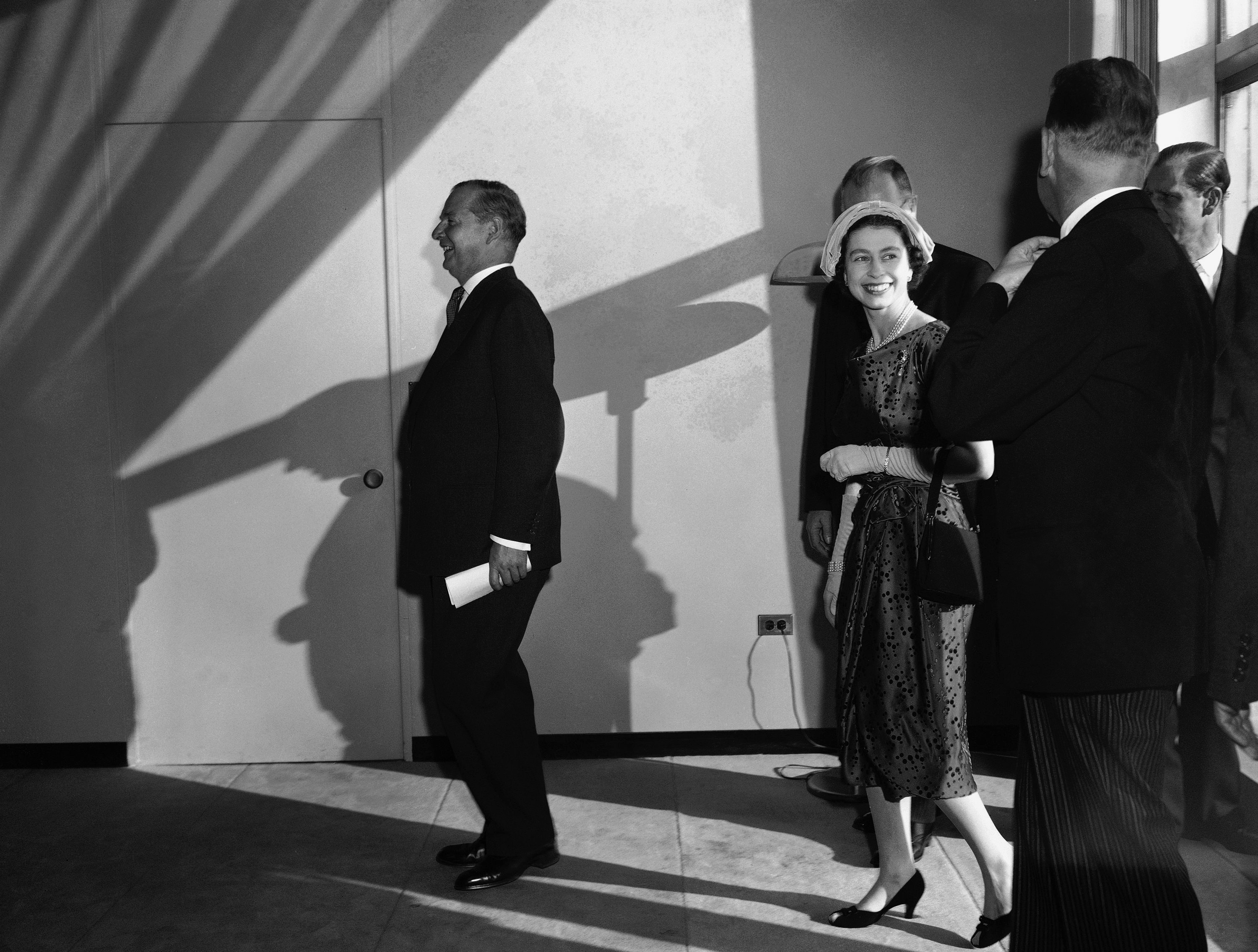 Alert Prince Andrew sits up in his carriage as his mother, Queen Elizabeth II, smiles down at him, when the baby prince was nearing his seventh month birthday, Sept. 13, 1960. (AP Photo)